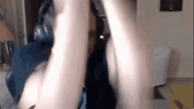a person 's arm is visible in a blurry photo in a room .