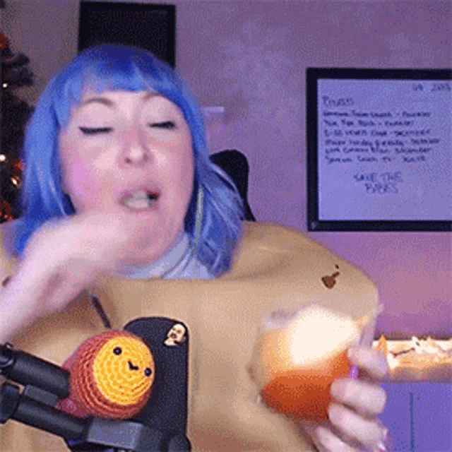 a woman with blue hair is holding an orange in front of a whiteboard that says " save the parks "