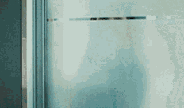 a close up of a glass door with a person standing behind it .
