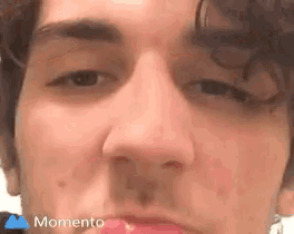 a close up of a man 's face with the word momento on the bottom right