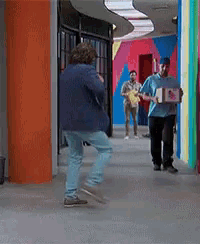 a man in a blue shirt is holding a box with a picture of a man on it