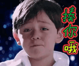 a young boy is making a sad face with chinese writing behind him