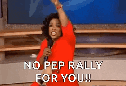 a woman in a red dress is holding a microphone and shouting .