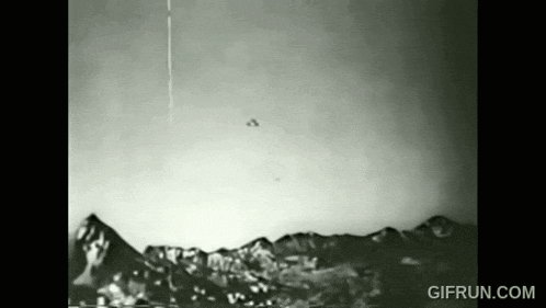 a black and white photo of a flying object over a mountain range .