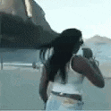 a woman in a white tank top is standing in front of a helicopter .