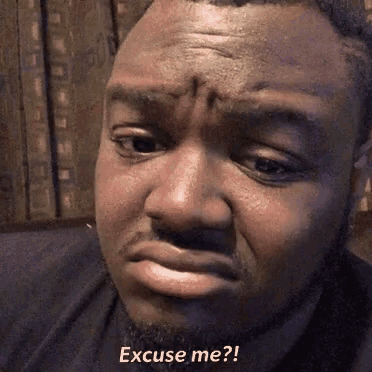 a close up of a man 's face with the words excuse me written on it