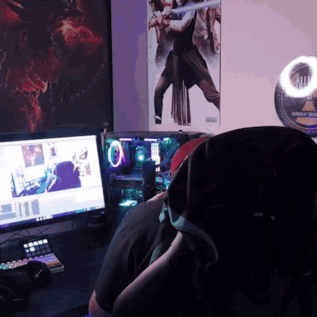 a person sitting in front of a computer with a poster on the wall that says ' starcraft ' on it
