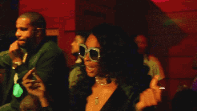 a woman wearing sunglasses is giving the middle finger to a man