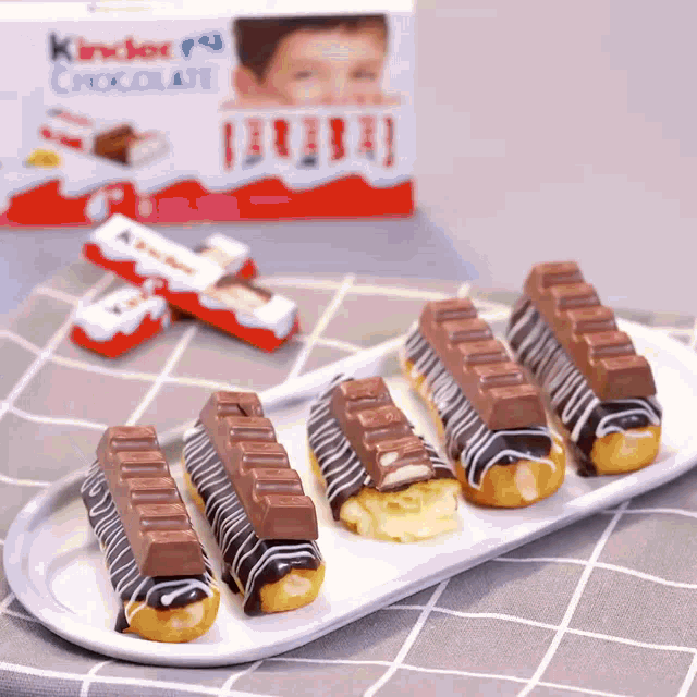 a box of kinder chocolates sits behind a white plate of desserts