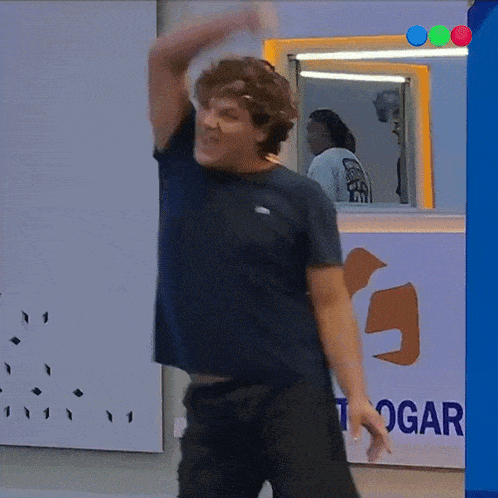 a man dancing in front of a togar sign
