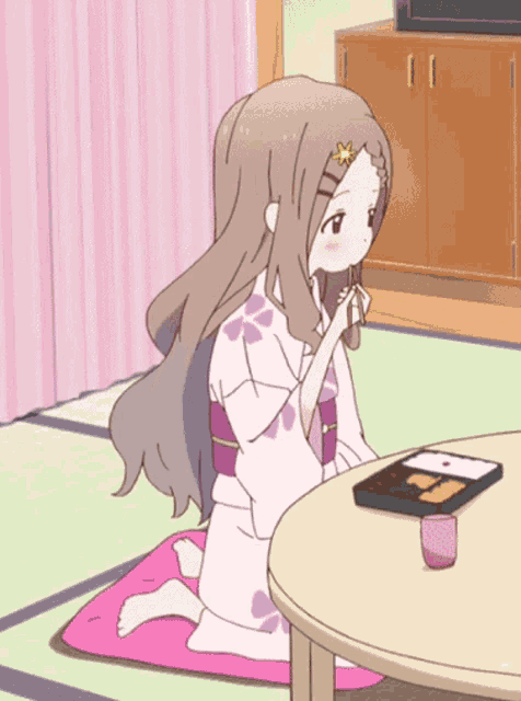 a girl in a kimono sits on the floor in front of a round table