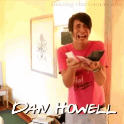 a man in a pink shirt with the name dan howell