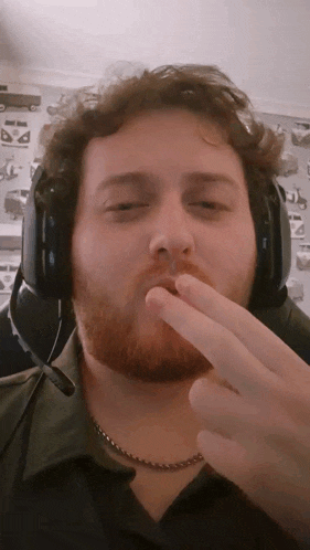 a man with a beard wearing headphones covering his mouth