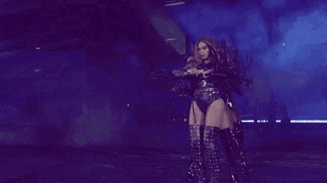 a woman is holding a microphone and dancing on stage