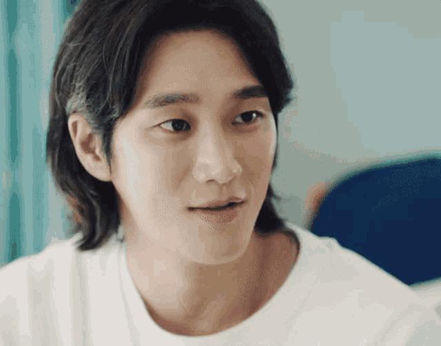 a close up of a man 's face with a white t-shirt on