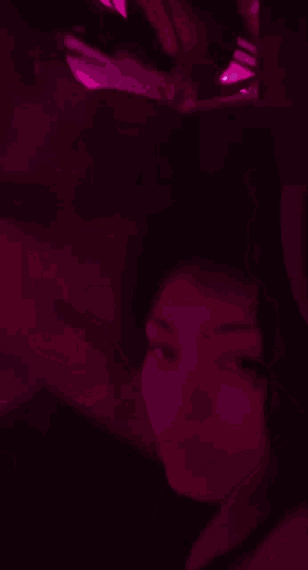 a person is dancing in a dark room with purple lights behind them .