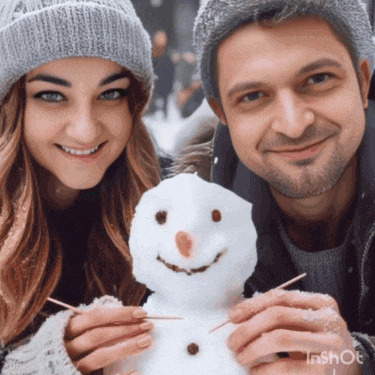 a man and a woman holding a snowman with toothpicks