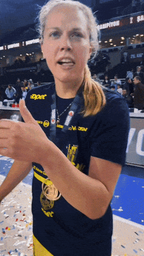 a woman with a medal around her neck is wearing a shirt that says ' expet ' on it