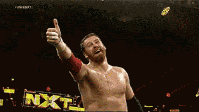 a shirtless wrestler is giving a thumbs up in front of a sign that says nxt .