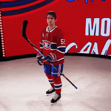 a hockey player with the number 52 on his jersey stands on the ice