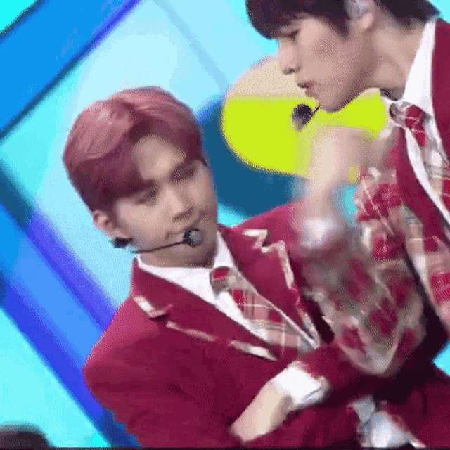 two men in red suits are standing next to each other on a stage .