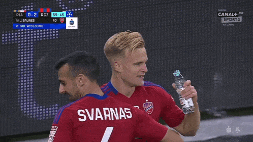 two soccer players one of whom has the name svarnas on the back of his shirt