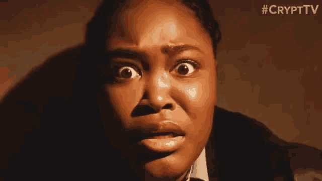 a woman with a surprised look on her face is looking at the camera .