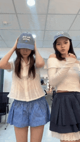 two girls wearing hats one of which says " i love you "
