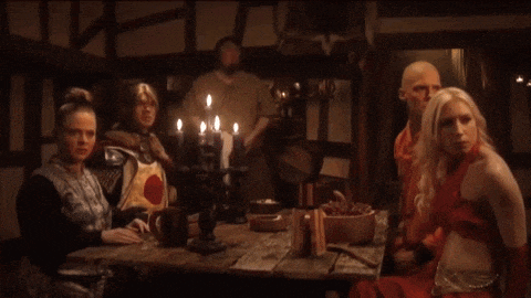a group of people sit around a table with candles on it