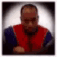 a blurry picture of a man wearing a red and blue jacket and tie .