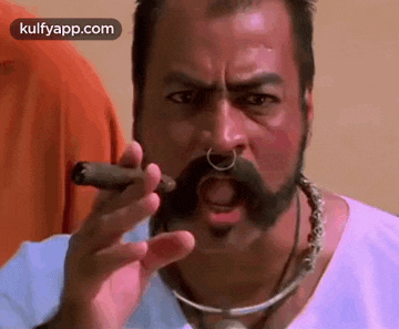 a man with a nose ring is smoking a cigar .