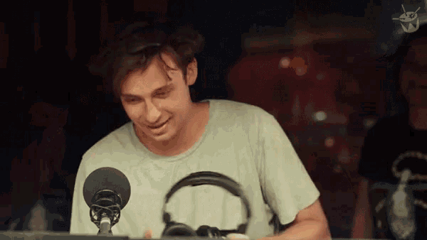 a man wearing headphones stands in front of a microphone ..