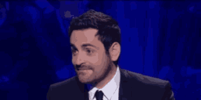 a man in a suit and tie is making a face