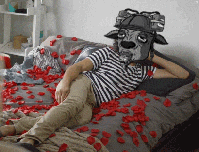 a person laying on a bed with a dog mask on