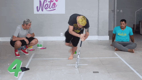 a man holding a bat in front of a neta sign