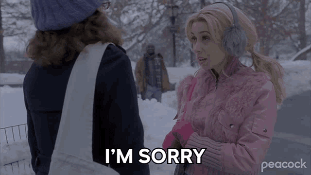 a woman in a pink jacket says i 'm sorry while standing in the snow