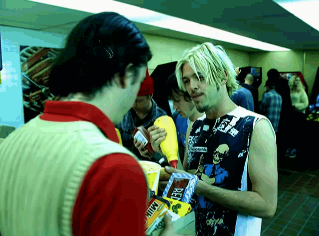a man holding a box of beef jerky talks to another man