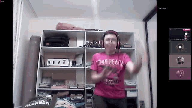 a man wearing headphones and a pink shirt that says 245 beach