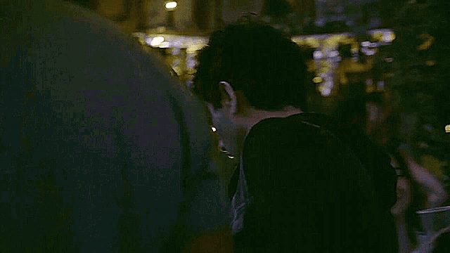 a group of people are standing in a dark room .