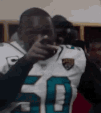 a man wearing a jaguars jersey is taking a picture of himself