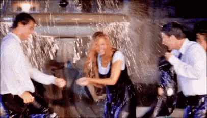 a group of people are standing in a room covered in water .