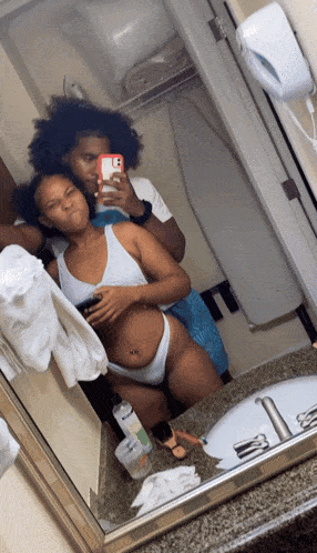 a man and woman are taking a selfie in a bathroom