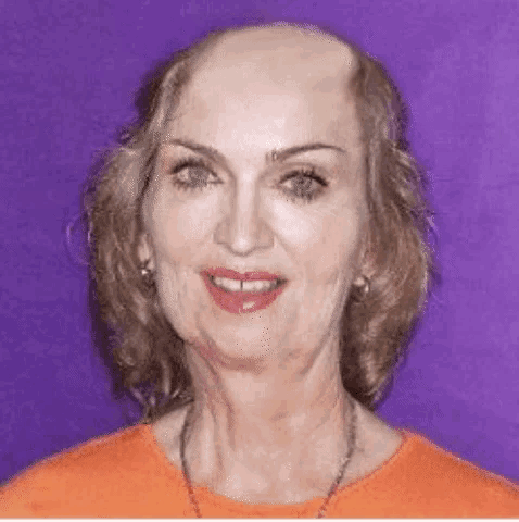 a woman with a bald head and a necklace is smiling .