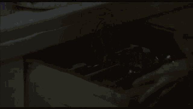 a person is opening a drawer filled with bottles and glasses
