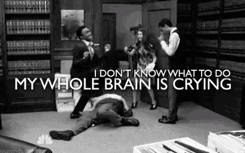 a group of people are standing around a man laying on the floor in a library .