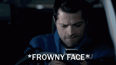 a man sitting in a car looking at a cell phone with the words * frowny face * written on the bottom