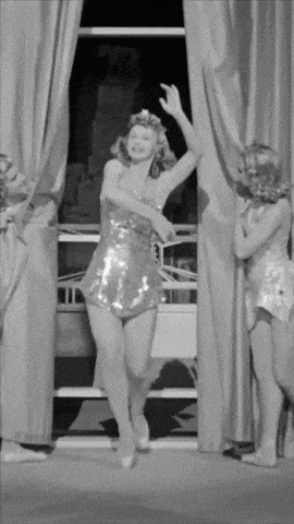 a woman in a sequined dress is dancing in a black and white photo