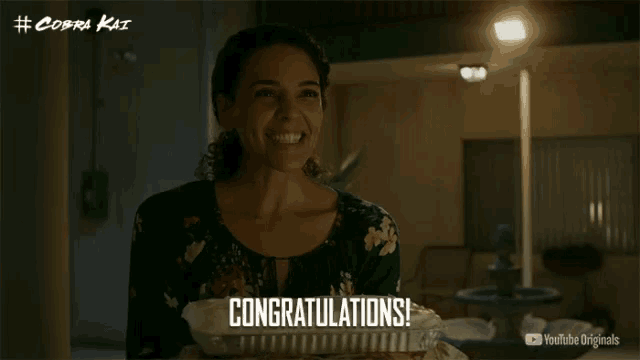 a woman holding a casserole dish with the words congratulations written on it