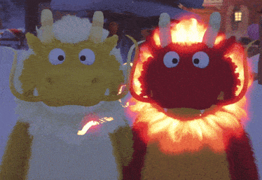two stuffed dragons one yellow and one red are standing next to each other in the snow