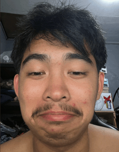 a man with a mustache is making a funny face in front of a mtb sticker